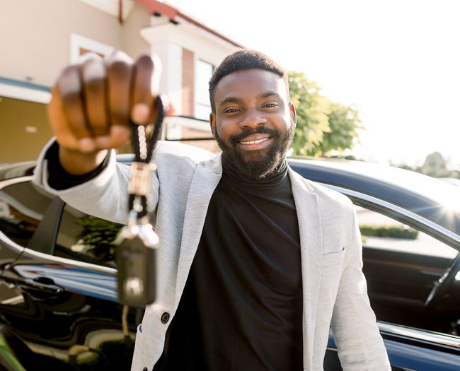 Sell Your Car Today! Man holding keys with his car in the background